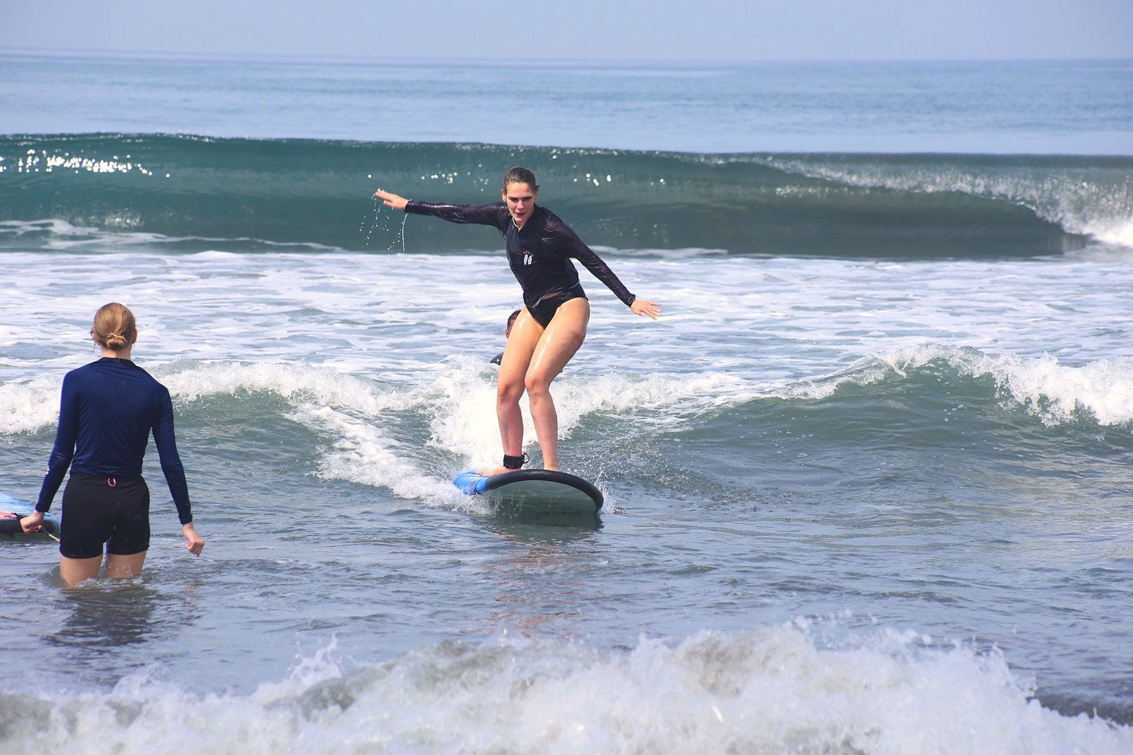 Student balancing on her board while a friend watches