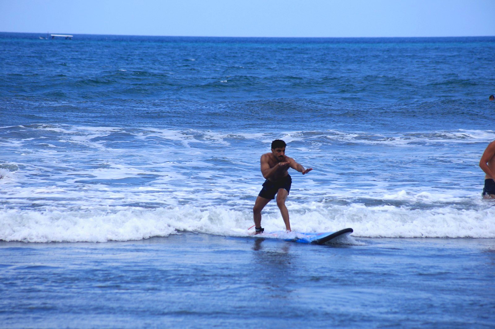 Surfer standing up on a small wave