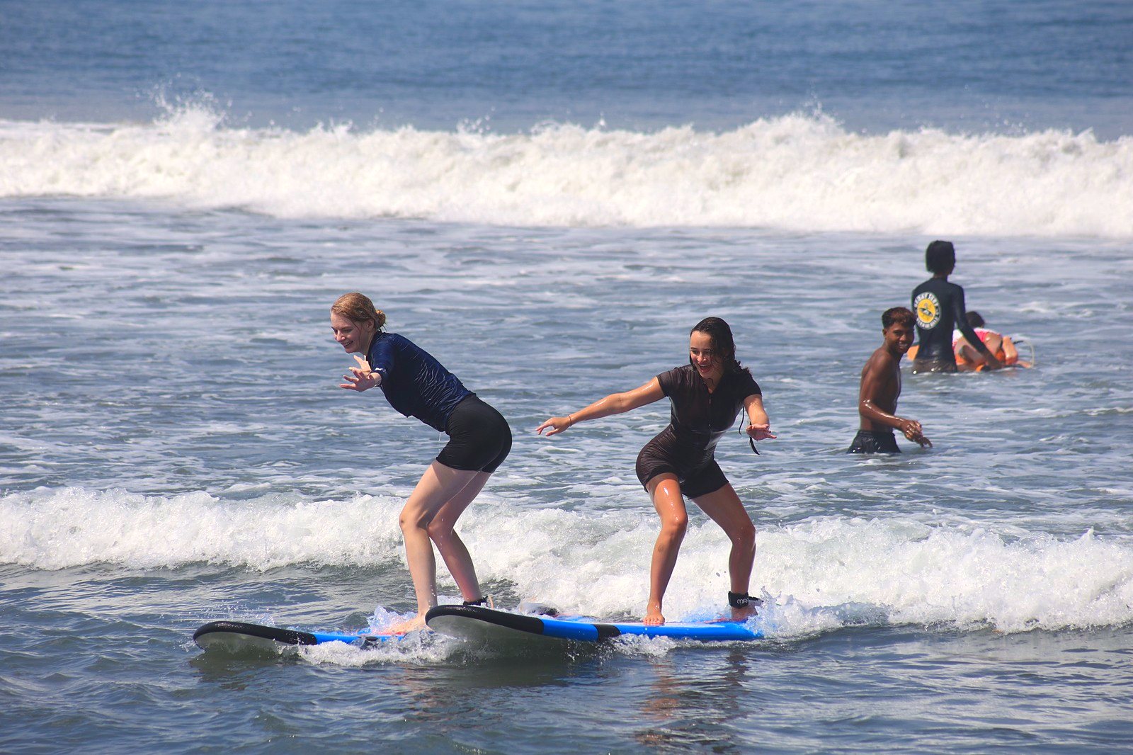 Two students riding side by side while an instructor cheers