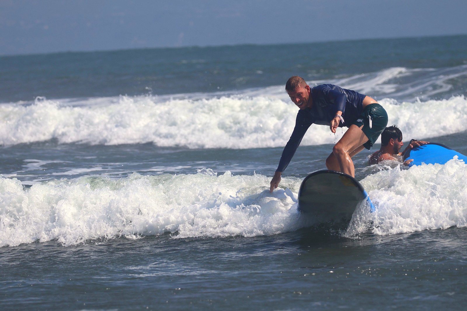 Surfer reaching for the wave as he rides in