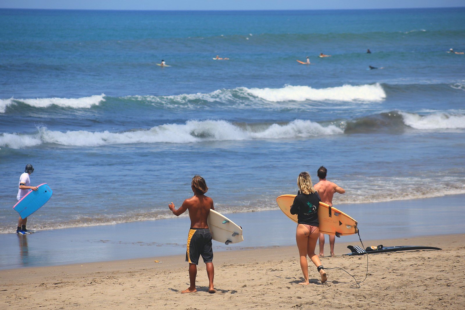 Surfers heading into the water with their boards