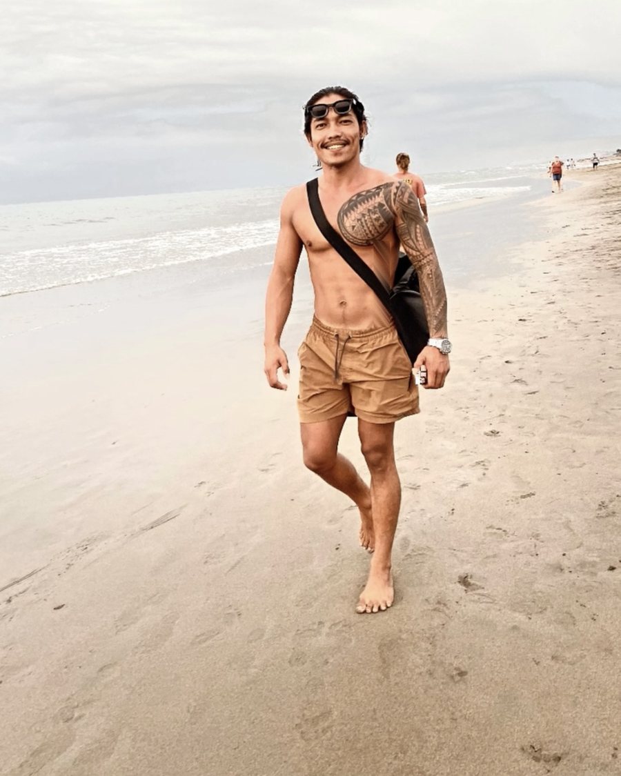 Gov smiling as he walks along the beach