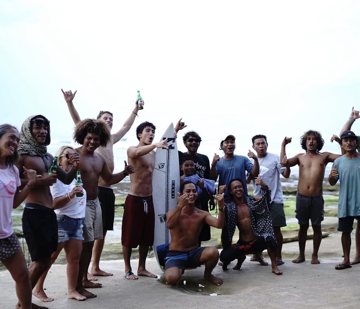 Gov celebrating with a big group of surfers and friends after a session
