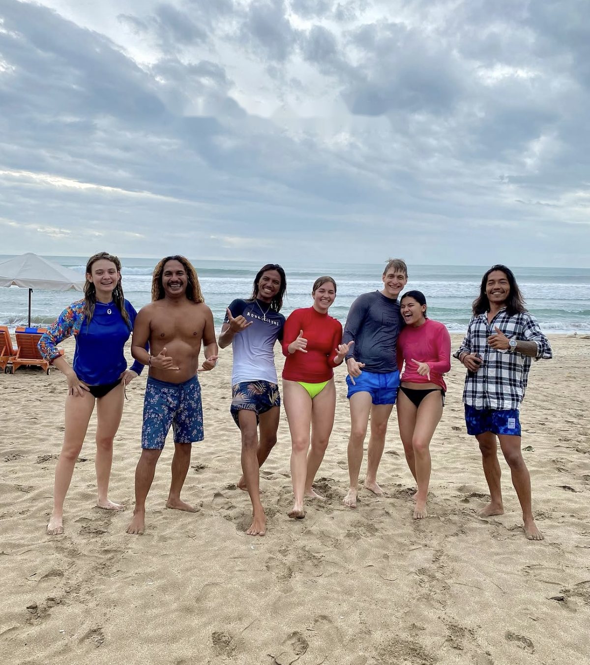 Gov and friends throwing shakas with surf retreat guests on the beach