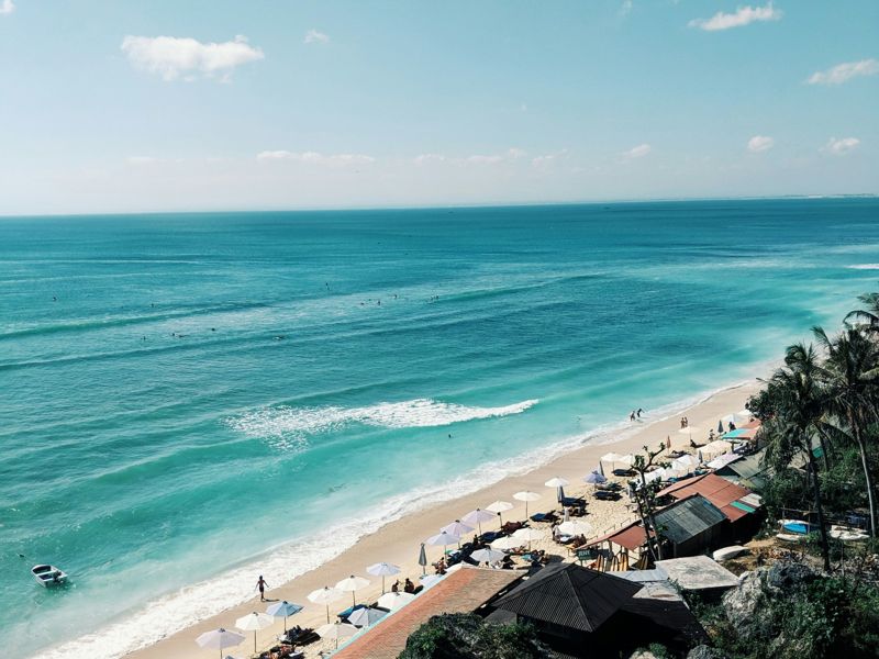 Aerial view of a beach with umbrellas and turquoise waves