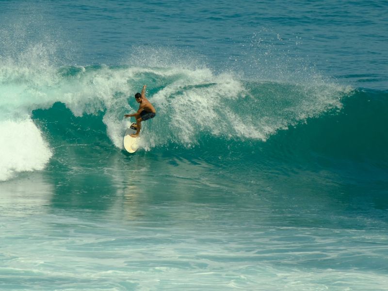 A surfer turning on a green wave